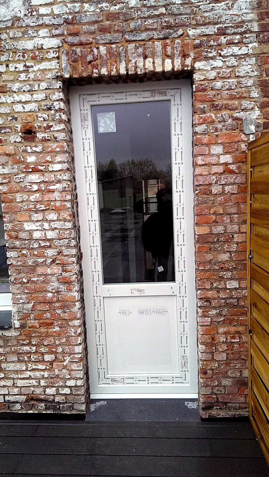 Nieuwe witte buitendeur tijdens plaatsing